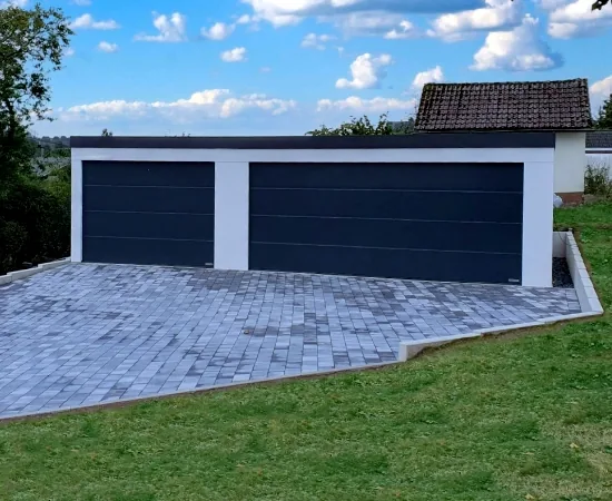 Fertige Großraumgarage mit zwei anthrazitfarbenen Toren