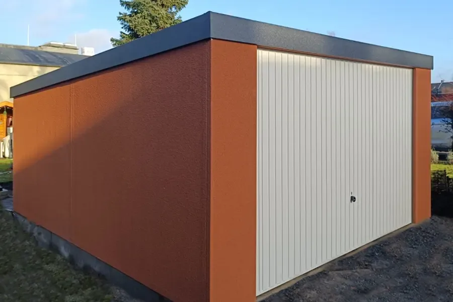 Stahlgarage mit terrakottafarbenem Dekorputz und weißem Tor
