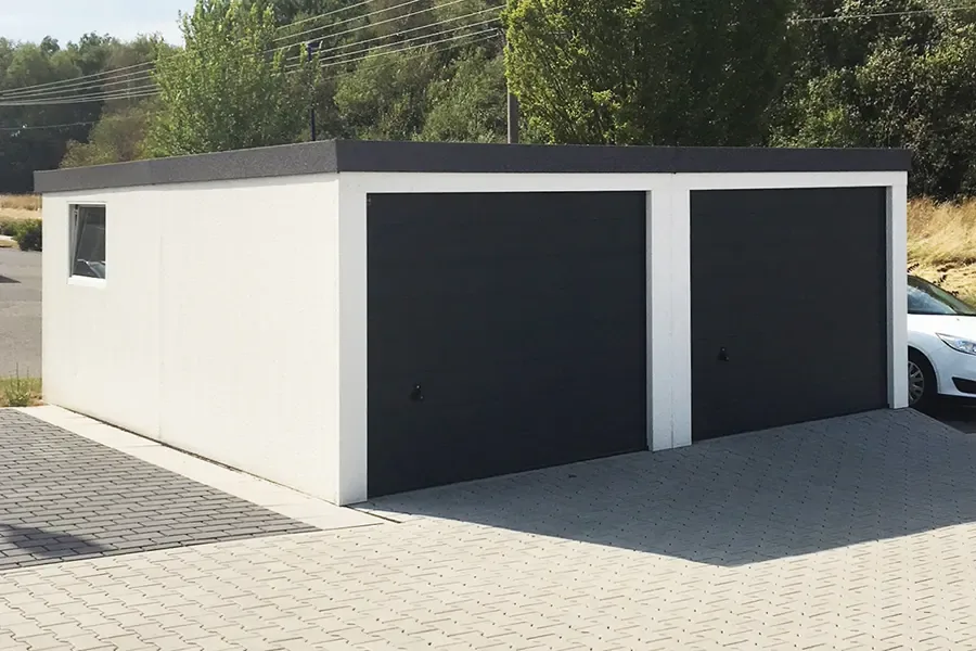 Weiße Doppelgarage mit zwei anthrazitfarbenen Sektionaltoren