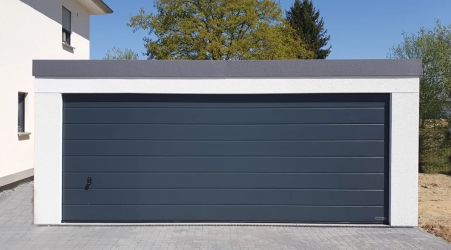Großraumgarage mit einem breiten anthrazitfarbenen Sektionaltor