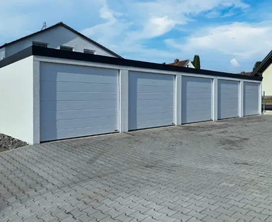 Garagenanlage mit fünf weißen Sektionaltoren
