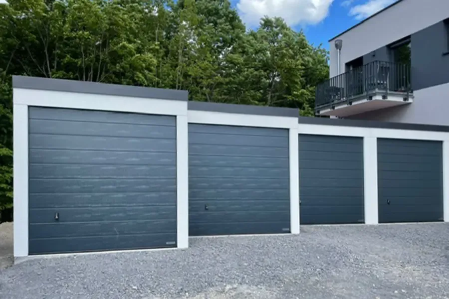 Garagenanlage mit vier anthrazitfarbenen Toren in Reihe